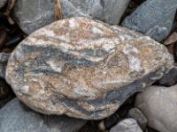 Keilförmiger Stein in Dunkelgrau, Hellbraun und Weiß